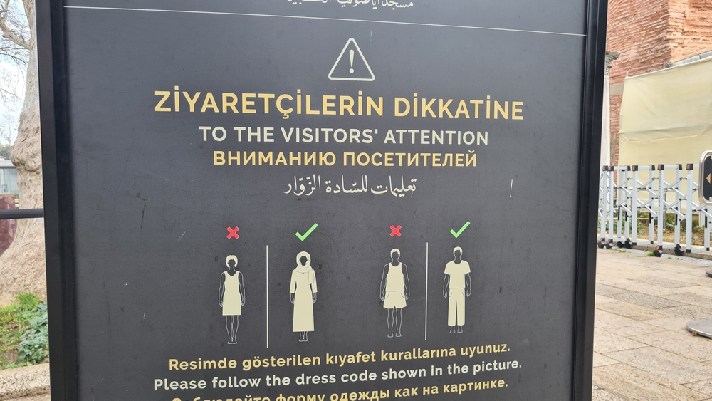 Hagia Sophia dress code sign for visitors showing headscarf and modest clothing rules at the mosque entrance in Istanbul