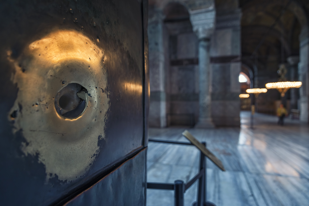 Nahaufnahme der Wunschsäule in der Hagia Sophia mit ihrer berühmten Marmoroberfläche und dem Fingerloch im historischen Innenraum